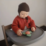 Jouet spinner Dino Mushie fixé grâce à sa ventouse sur une chaise haute