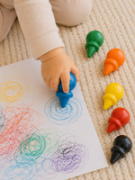 bébé d'un an qui dessine sur une feuille avec les crayons ergonomiques créalign 