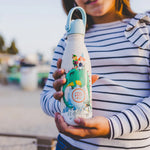 une fille tient une gourde 350 ml dragon dans sa main 