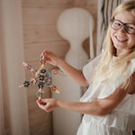 Enfant manipulant les disques du jouet de construction Mushie Hex Connect